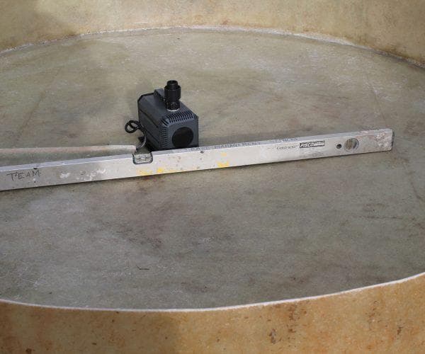 The pump seated in the centre of the base pool with its cable routed out